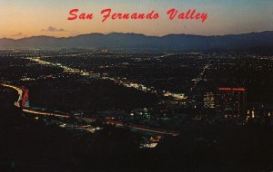 Aerial view of  Universal City at sunset, showing city lights. Foreground shows the 101 (Hollywood Fwy) and Sheraton Universal Hotel. 1980s-90s?